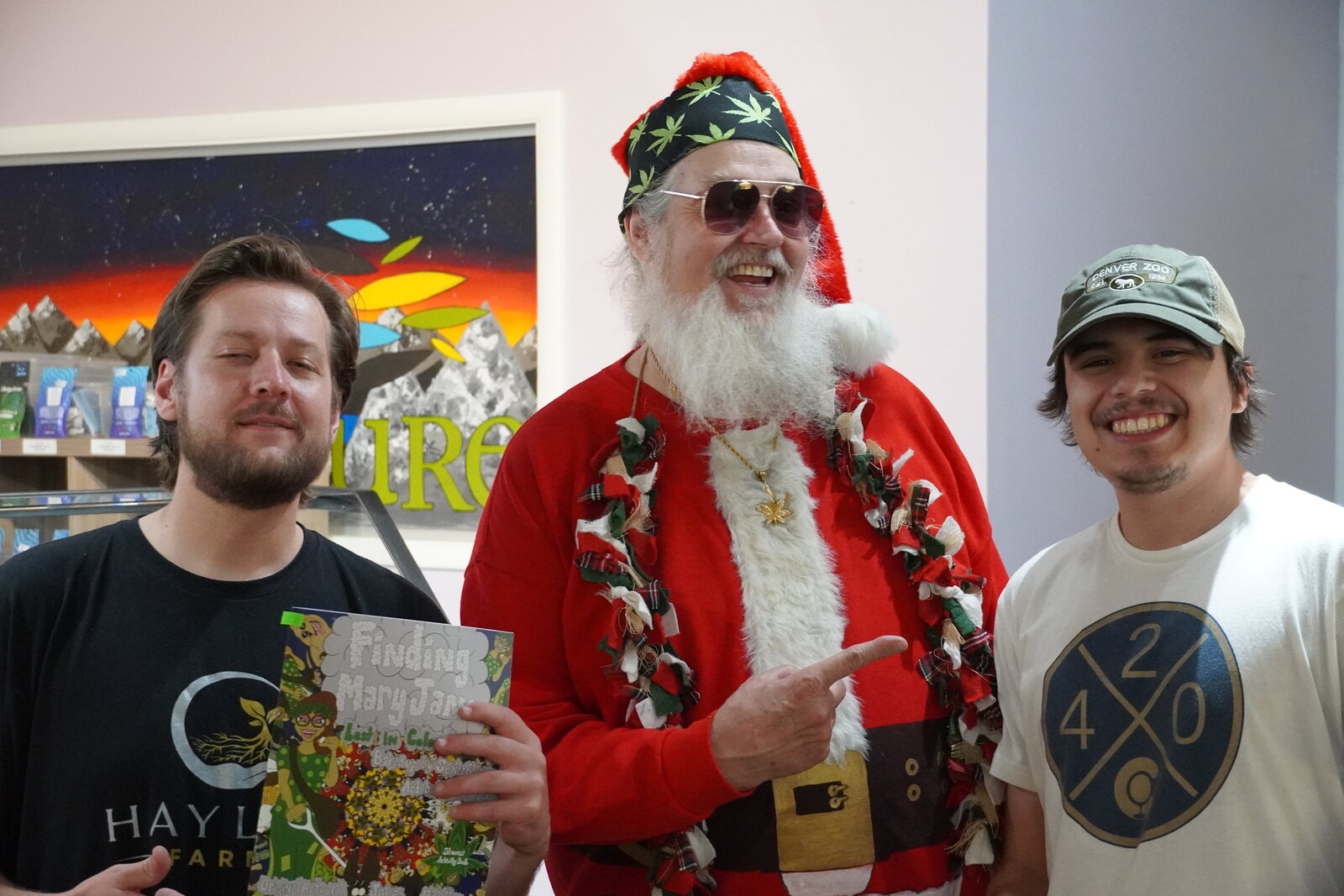 Smoking Santa with two customers, one holding a gift